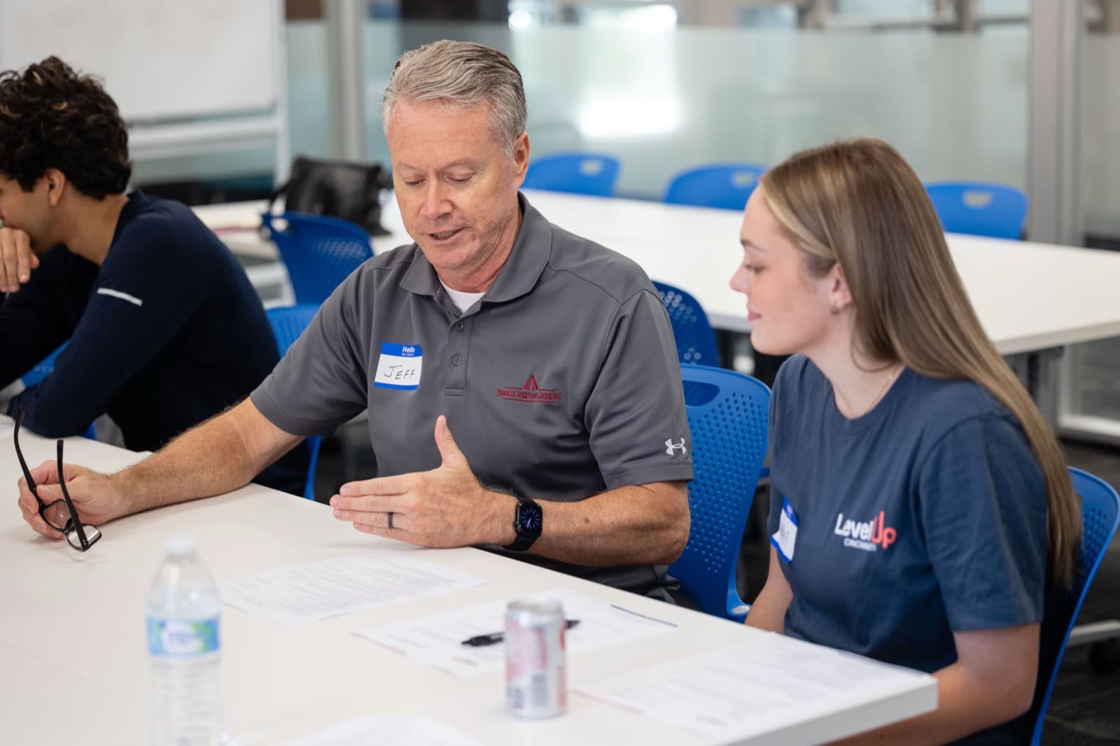 A volunteer walks a Level Up scholar through her materials at Professional Development Day